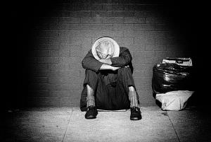 Homeless man sleeping on the sidewalk 1972 Los Angeles, CA by social documentary photographer Daniel D. Teoli Jr.
