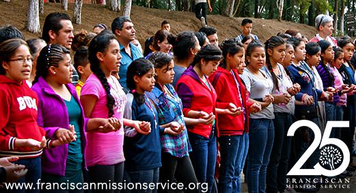 Children in Guatemala praying in a line with hands grasped together