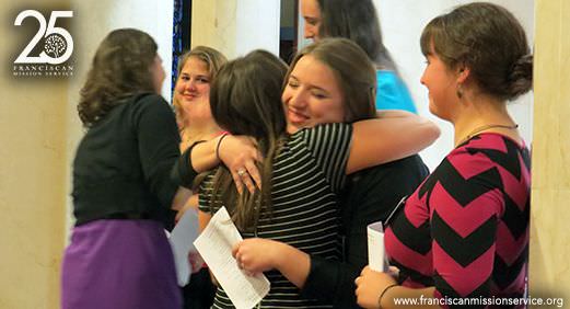 Executive Director Kim Smolik congratulates missioner-in-training Aubrey Kimble with a hug