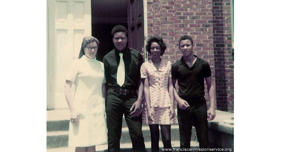 Sister Cathy with students in front of church 1970